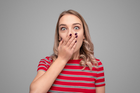 Shocked young lady covering mouthの写真素材