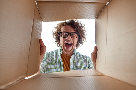 Man in glasses looking inside box
