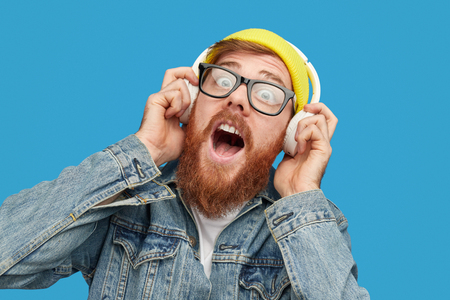 Bearded hipster listening to loud musicの写真素材