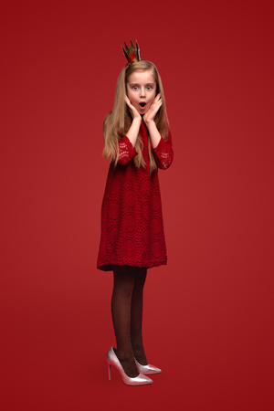 Shocked little princess in adult shoesの写真素材