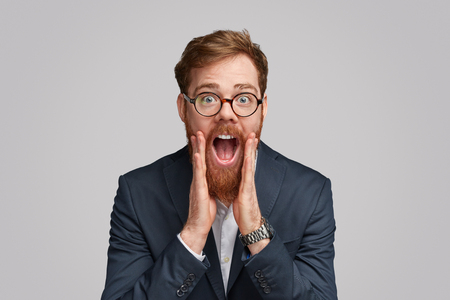 Excited ginger businessman making announcementの写真素材