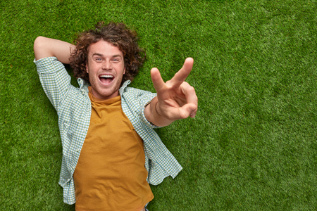 Man on grass showing V signの写真素材