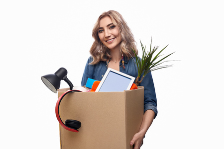 Smiling woman carrying carton box with belongings