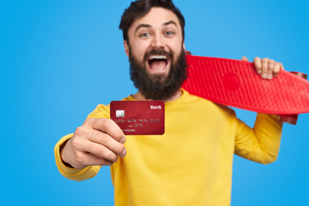 Pleased hipster showing credit cardの写真素材