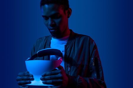 Black guy examining VR helmet