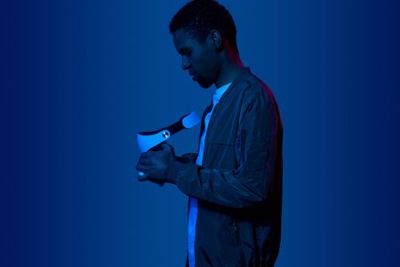 Black man examining VR helmet