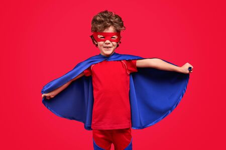 Cheerful superhero spreading capeの写真素材