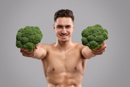 Fit man offering broccoliの写真素材
