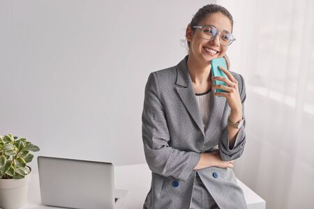 Cheerful office worker with smartphoneの写真素材