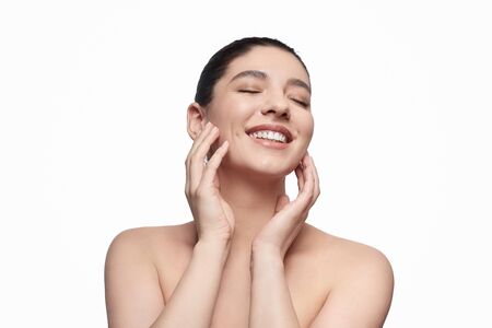 Cheerful lady touching clean faceの写真素材