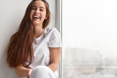 Laughing teenager near window