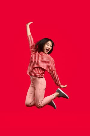 Cheerful Asian woman leaping upの写真素材