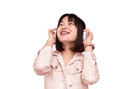 Cheerful Asian female listening to musicの写真素材