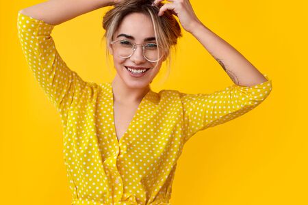 Cheerful young lady touching hairの写真素材