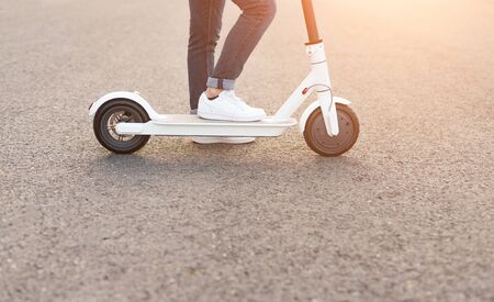 Crop man riding electric scooterの写真素材