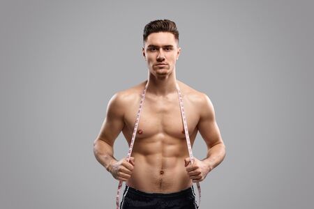 Muscular guy with tape measureの写真素材