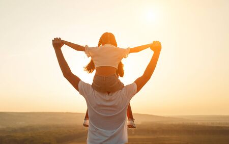 Anonymous father and daughter during sundownの写真素材