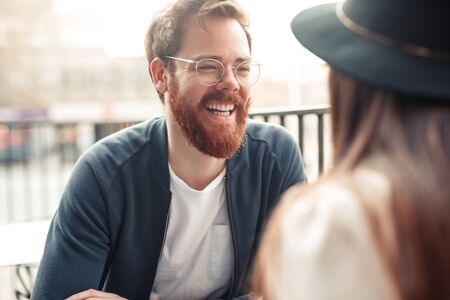 Bearded man laughing with friendの写真素材