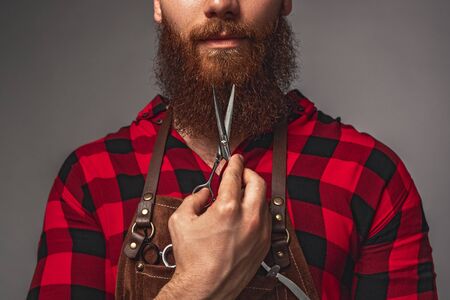 Anonymous bearded barber with scissors