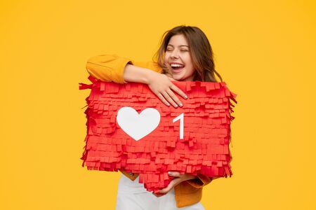 Excited young female hugging like sign