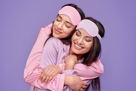 Happy women hugging during sleepoverの写真素材