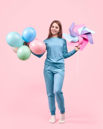 Cute teenager with balloons and pinwheelの写真素材