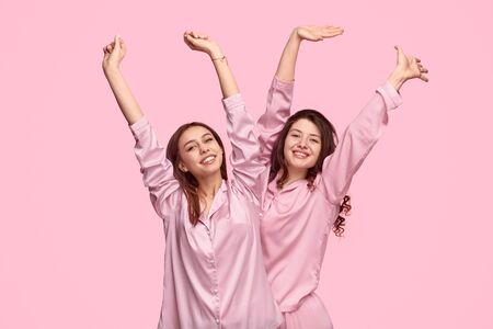 Cheerful friends stretching arms in morningの写真素材