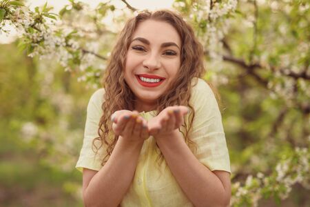 Cheerful lady in blooming spring garden