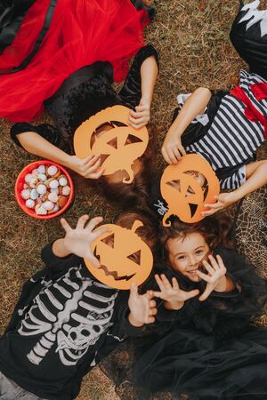 Children with candies and spooky pumpkin masksの写真素材