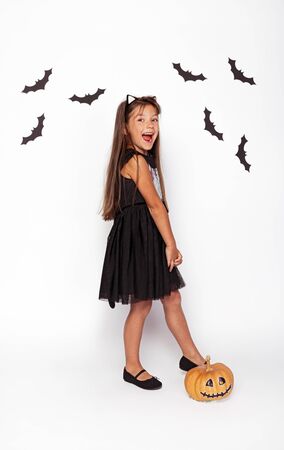 Joyful girl with pumpkin and paper batsの写真素材