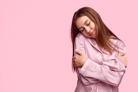 Young woman embracing body during sleepの写真素材