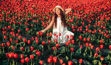 Happy female amidst red flowersの写真素材