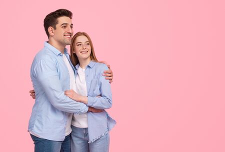 Dreamy couple hugging and looking awayの写真素材