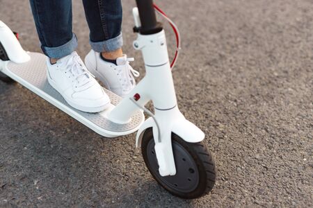 Crop man riding electric scooter