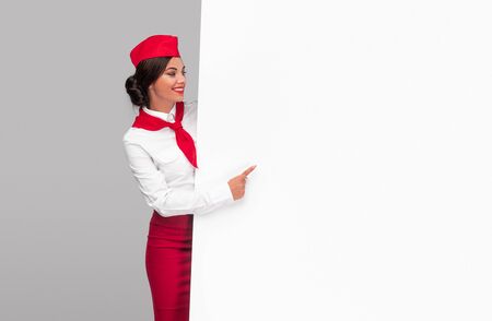 Delighted air hostess pointing at empty placardの写真素材