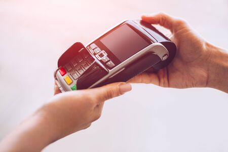 Crop cashier giving payment terminal to client