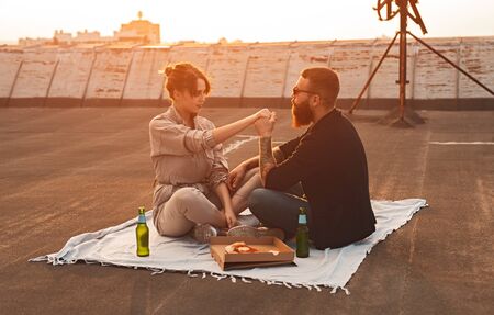 Couple having romantic picnic on rooftopの写真素材