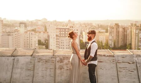 Stylish couple holding hands on roof
