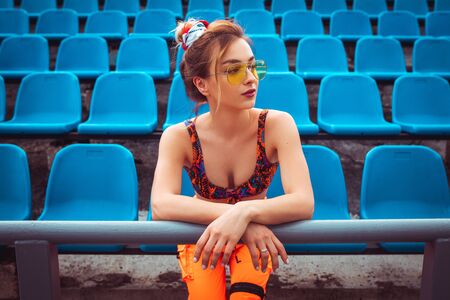 Stylish female athlete during break on stadiumの写真素材