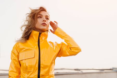 Dreamy young female in stylish jacket
