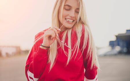 Stylish woman biting sunglassesの写真素材