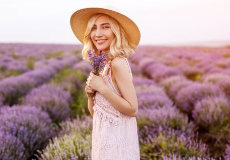 Cheerful woman with lavenders in fieldの写真素材