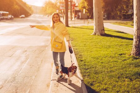 Woman with dog catching cab on roadsideの写真素材