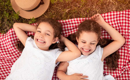 Cheerful twins lying on blanket togetherの写真素材