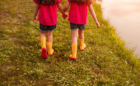 Crop sisters walking near water in park