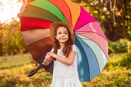 Cute girl with umbrella in gardenの写真素材