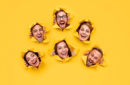 Excited people tearing yellow paperの写真素材