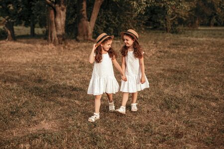 Twin sisters walking in park together