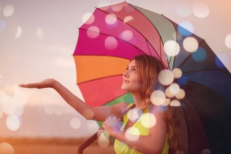 Young lady with umbrella during summer rainの写真素材