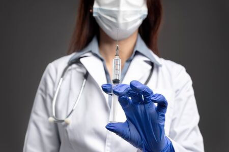 Crop nurse showing syringe of vaccineの写真素材